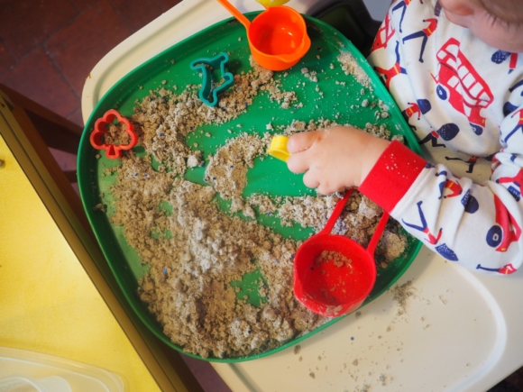 child playing cloud dough tray