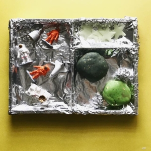 Space invitation to play  I covered a tray with foil to give a different background, re-used some play dough and dyed half black with food gel, added some small world astronauts + spaceships with a few stars.