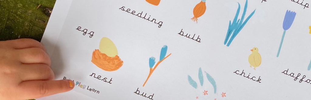 kids hand pointing at a spring word mat
